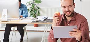 un-homme-mangeant-une-pomme-au-bureau