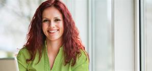 woman-laughing-at-her-work-in-front-of-a-laptop