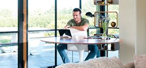 man-looking-at-his-tablet-in-the-kitchen-with-a-headset